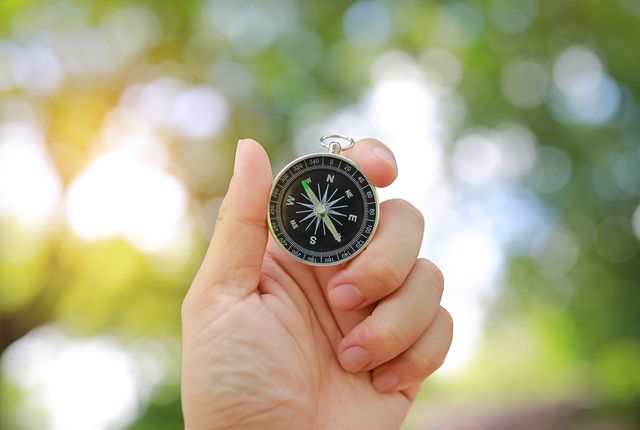 Eine Hand hält einen Kompass, der nach Nordwesten zeigt