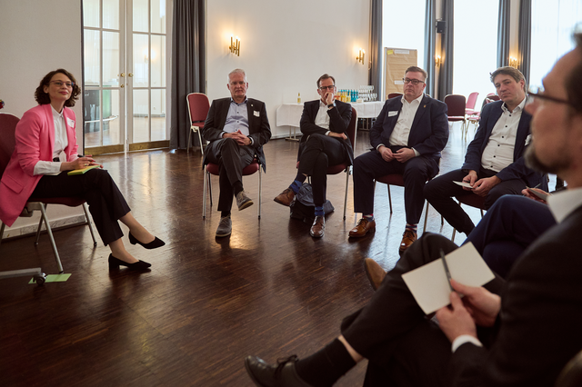 Foto von Personen, die in einem Stuhlkreis sitzen